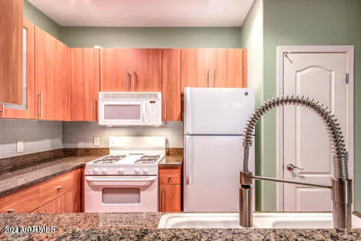 a kitchen with a refrigerator sink and cabinets
