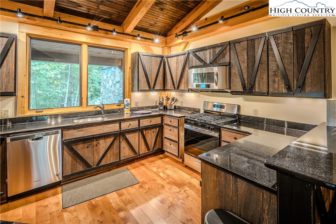 161 Hump View Trail Banner Elk, NC 28604 - Photo 12 of 50 a kitchen that has a sink a stove and a wooden floor