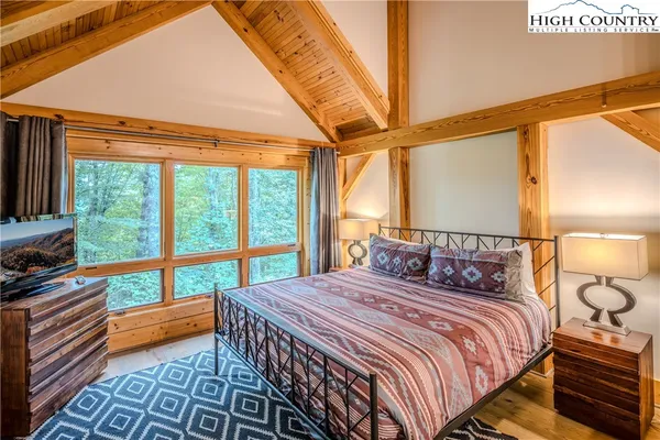 a bedroom with a bed and a large window with outer view