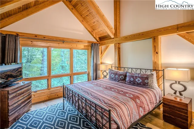 a bedroom with a bed and a large window with outer view