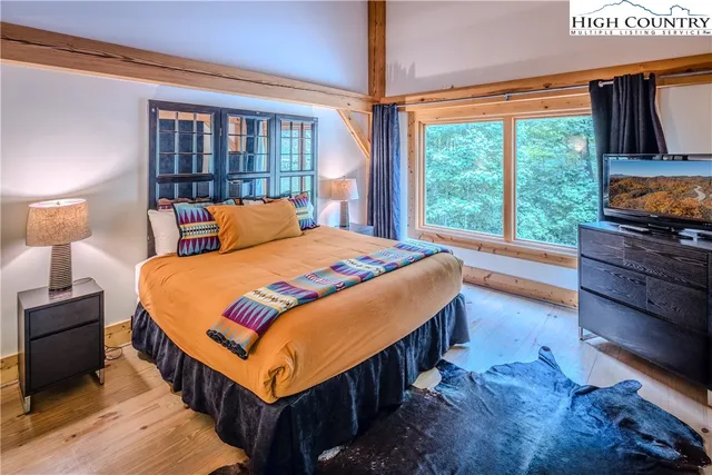 a bedroom with a bed and a dresser next to a window