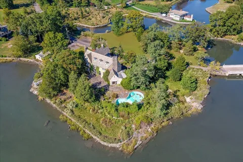 an aerial view of a house with a yard and lake view
