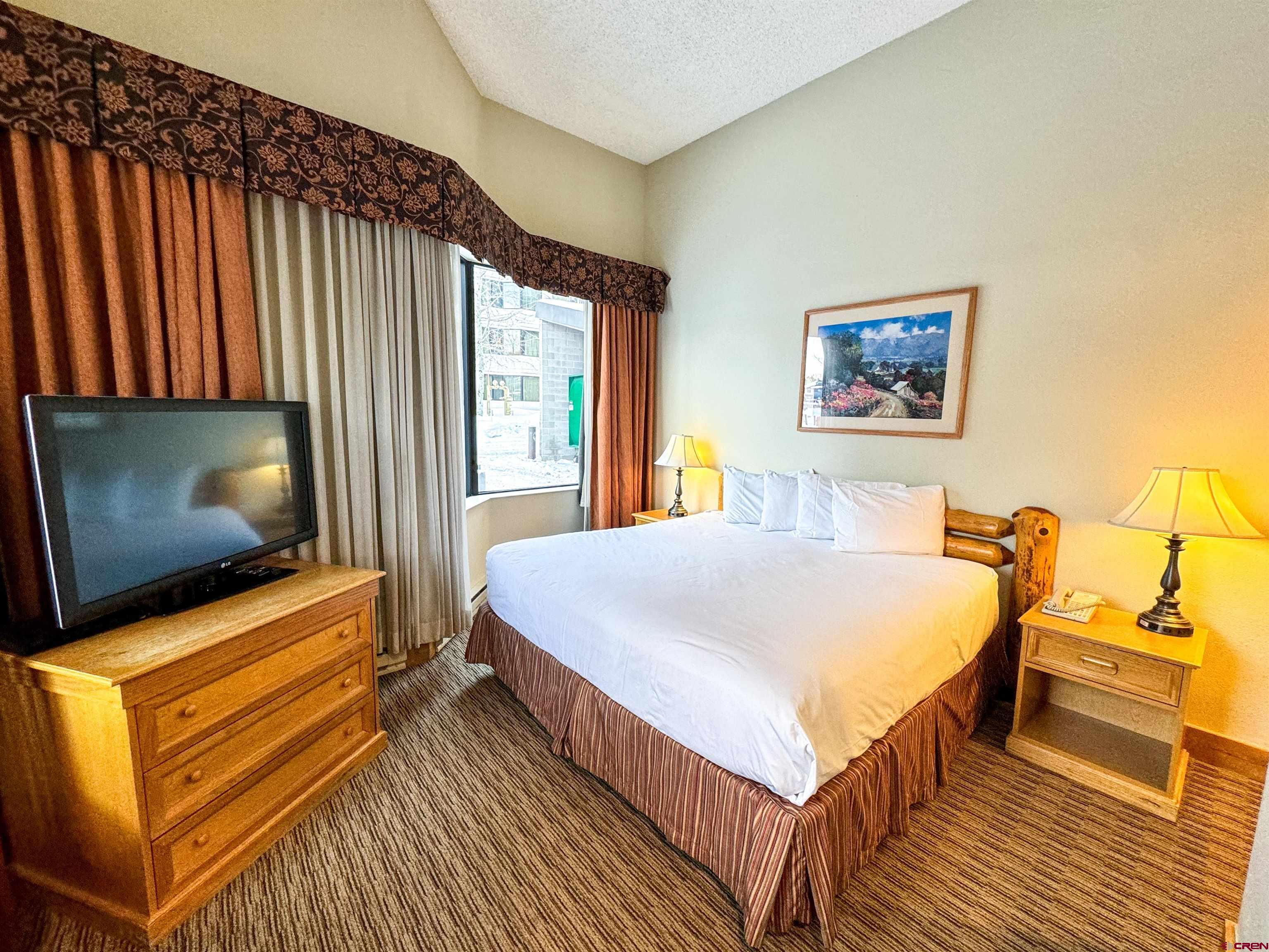 a bedroom with a bed and a flat screen tv