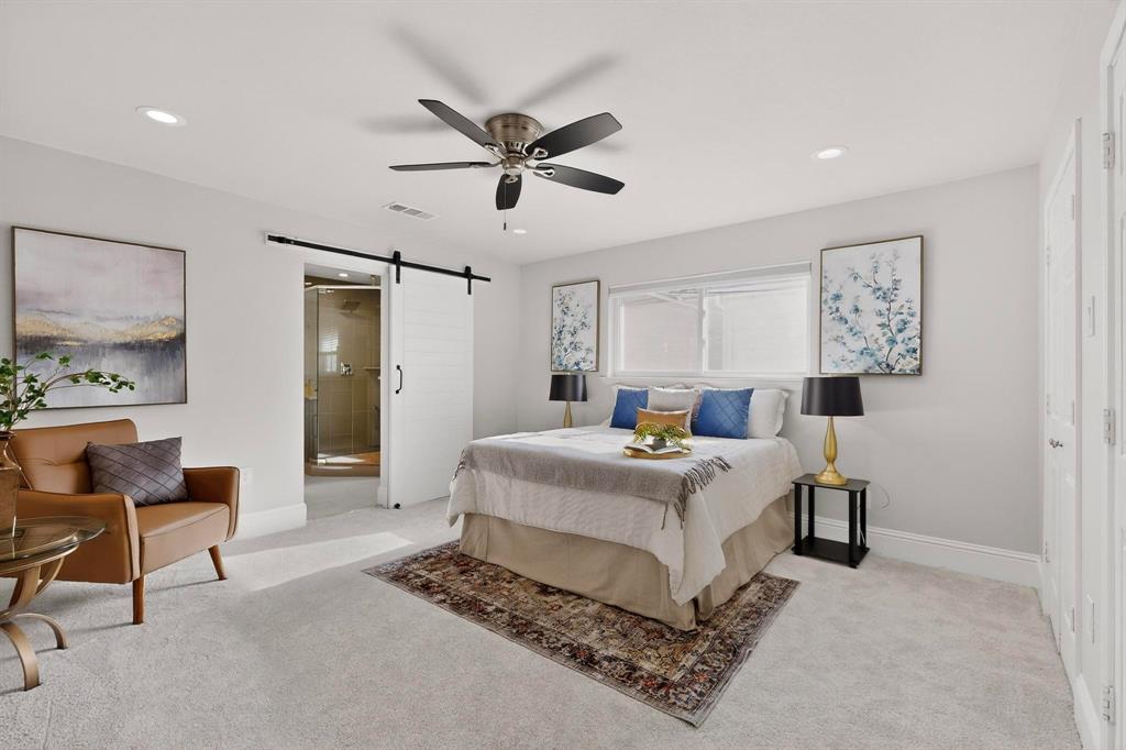 7625 Querida Lane Dallas, TX 75248 - Photo 13 of 32 a spacious bedroom with a bed a table and chair