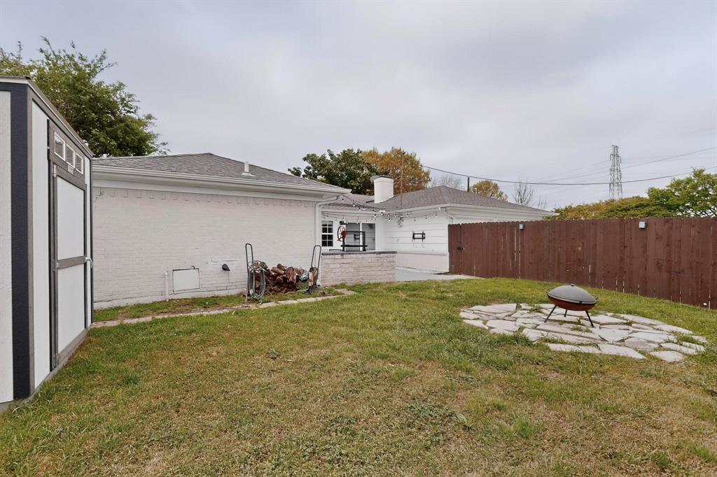 7625 Querida Lane Dallas, TX 75248 - Photo 30 of 32 a view of a backyard with table and chairs and wooden fence