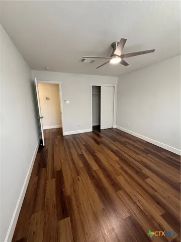 a view of a livingroom with wooden floor and a ceiling fan