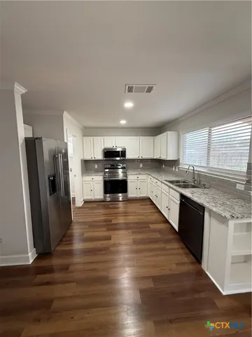 a large kitchen with stainless steel appliances granite countertop a refrigerator and a stove top oven