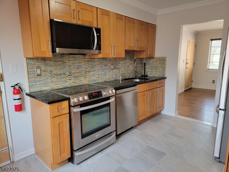 21C Troy Drive Springfield, NJ 07081 - Photo 11 of 17 a kitchen with stainless steel appliances granite countertop a stove microwave and sink