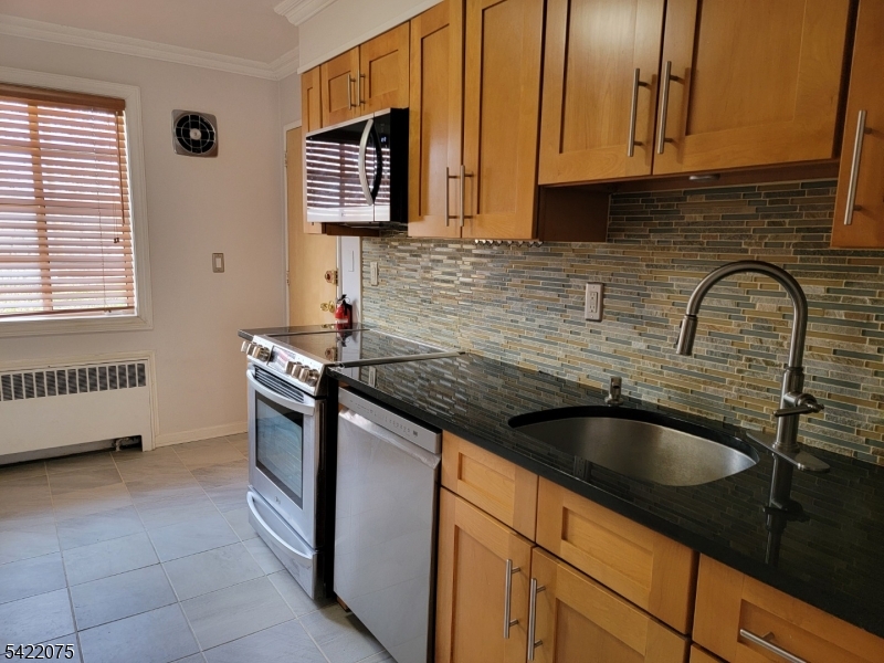 21C Troy Drive Springfield, NJ 07081 - Photo 13 of 17 a kitchen with granite countertop a sink a stove and cabinets