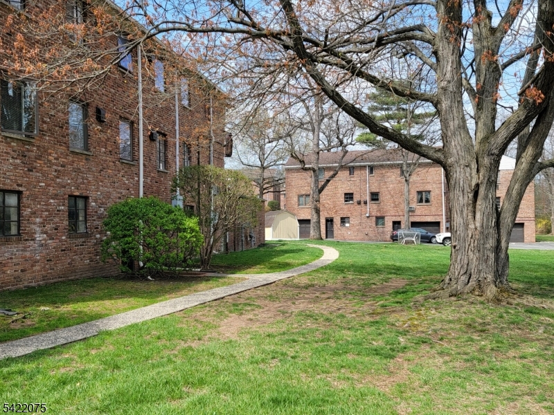 21C Troy Drive Springfield, NJ 07081 - Photo 7 of 17 a view of a white house with a big yard and large trees