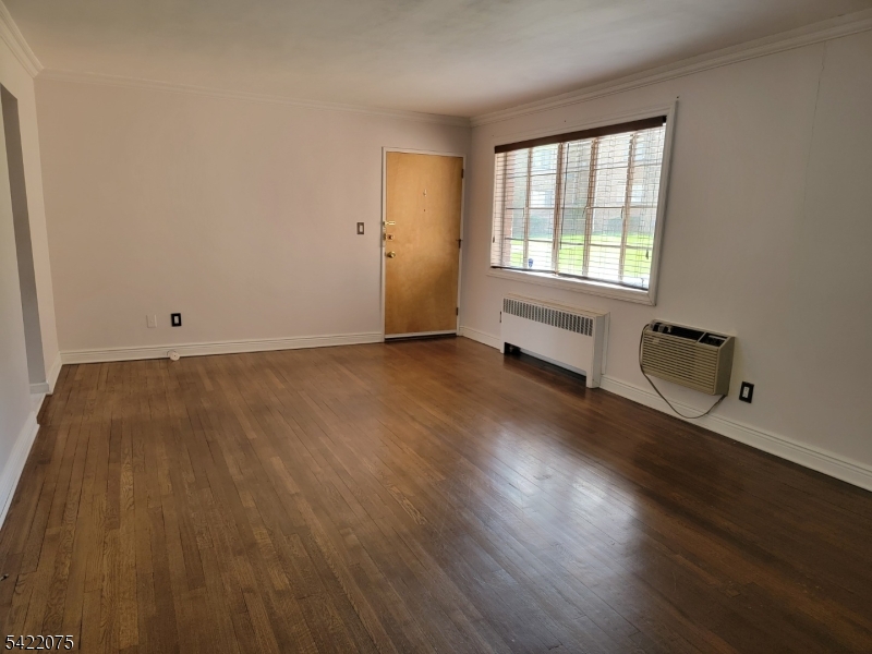 21C Troy Drive Springfield, NJ 07081 - Photo 8 of 17 an empty room with wooden floor and windows