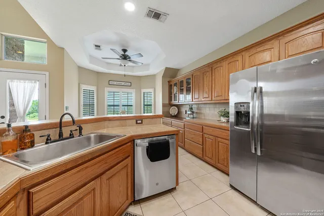 a kitchen with stainless steel appliances a sink a stove a refrigerator and island