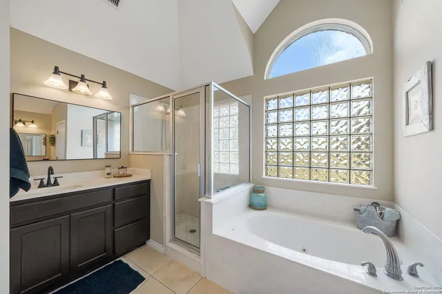 a bathroom with a tub a sink and mirror