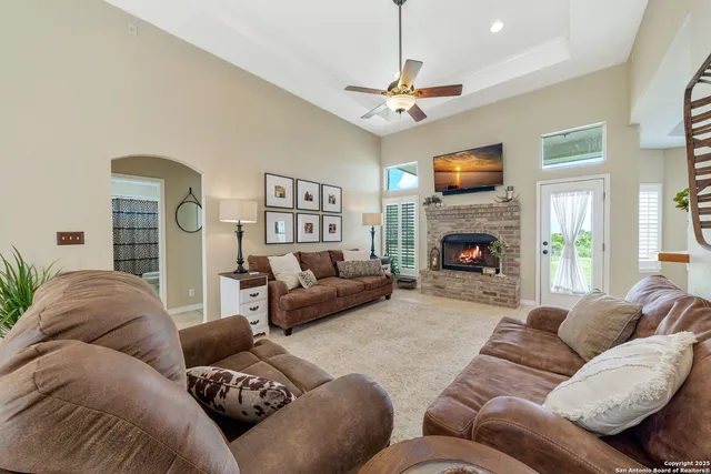 a living room with furniture a fireplace and a flat screen tv