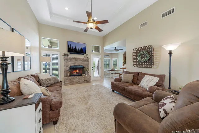 a living room with furniture a fireplace and a flat screen tv
