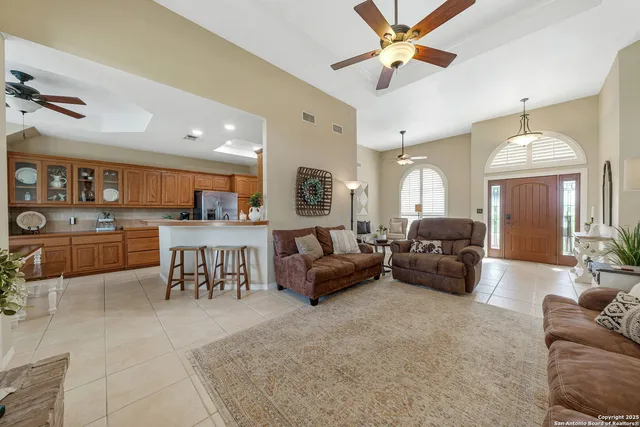 a living room with furniture kitchen view and a chandelier