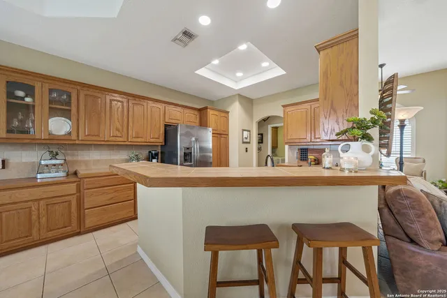 a kitchen with stainless steel appliances granite countertop a table chairs sink and cabinets