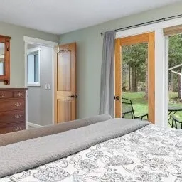 a bedroom with a bed mirror and a large window