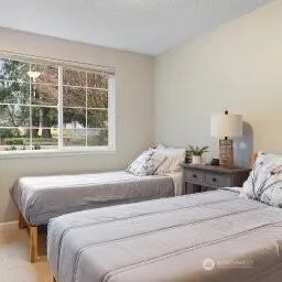 a bedroom with bed and a large window