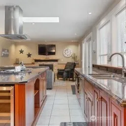 a kitchen with stainless steel appliances granite countertop a stove a sink and a microwave