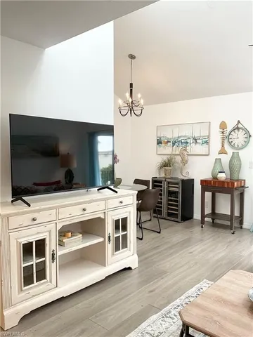 a living room with furniture a flat screen tv and kitchen view