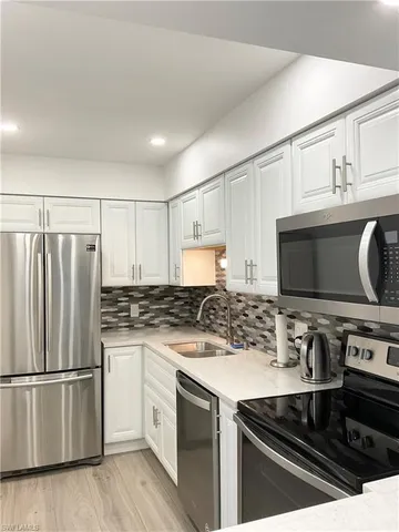a kitchen with granite countertop a stove microwave and sink