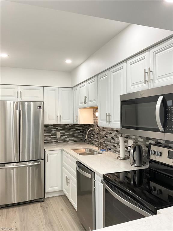 964 8th Avenue South, Unit B2 Naples, FL 34102 - Photo 15 of 37 a kitchen with a stove a sink and a refrigerator