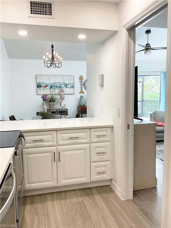 964 8th Avenue South, Unit B2 Naples, FL 34102 - Photo 19 of 37 a kitchen with a cabinets and chandelier