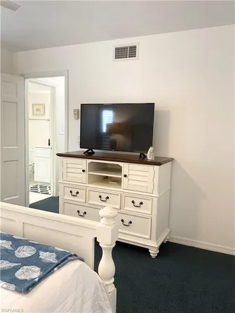 a bedroom with a bed and a night stand