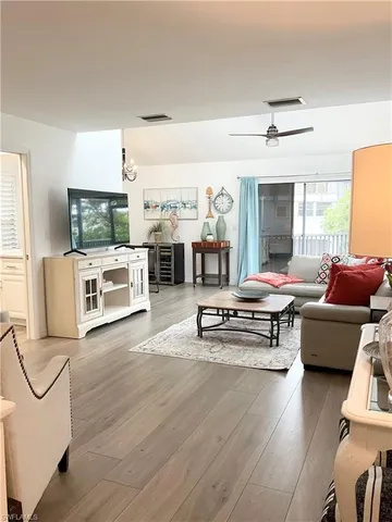 a living room with a flat screen tv and kitchen view