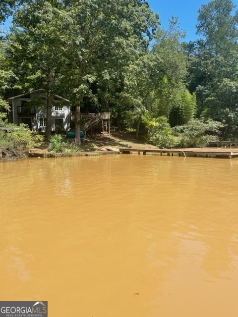 132 Collins Road Jackson, GA 30233 - Photo 2 of 39 a view of a swimming pool with a lawn chairs under an umbrella