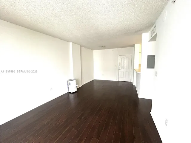 a view of an empty room and wooden floor
