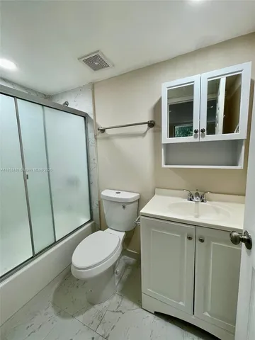 a bathroom with a toilet sink and shower