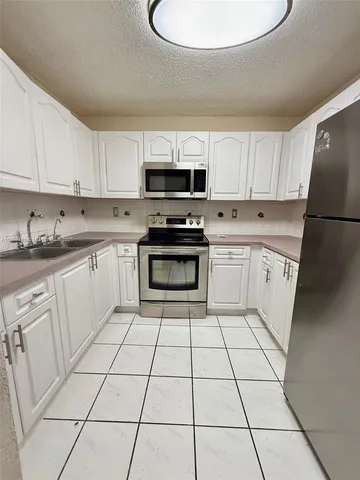 a kitchen with a stove a sink dishwasher and a refrigerator