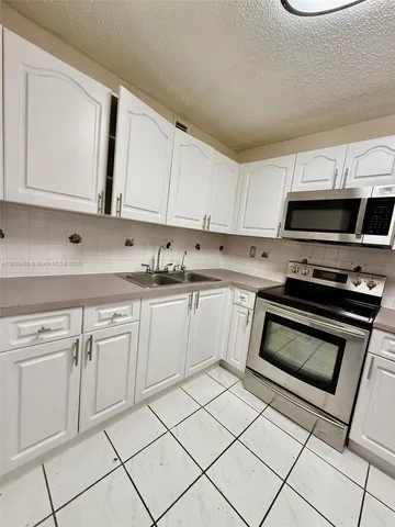 a kitchen with cabinets appliances and a sink
