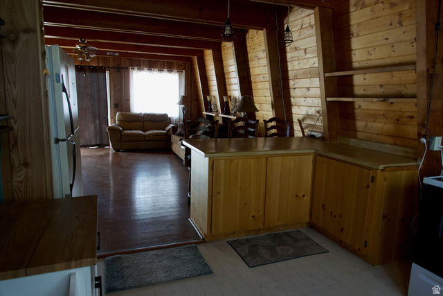 140 East Rim Road Duck Creek Village, UT 84762 - Photo 43 of 45 Kitchen with wooden walls, a peninsula, open floor plan, light countertops, and freestanding refrigerator