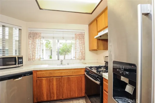a kitchen with stainless steel appliances granite countertop a sink stove and refrigerator