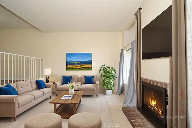 a living room with furniture a flat screen tv and a fireplace