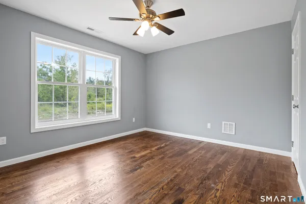 a view of an empty room with wooden floor