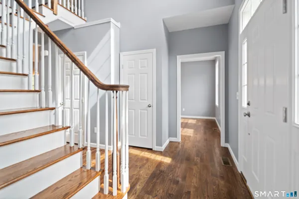 a view of a hallway with wooden floor and staircase