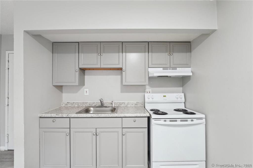 1150 Ogden St Extension, Unit 208 Bridgeport, CT 06610 - Photo 2 of 7 a kitchen with a sink a stove and cabinets
