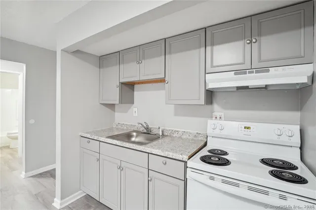 a kitchen with white cabinets and appliances