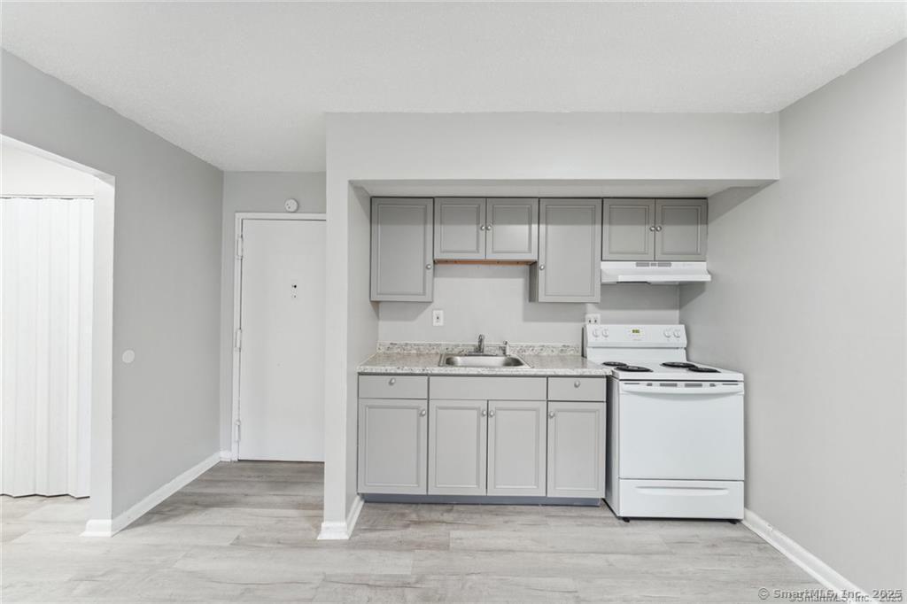 1150 Ogden St Extension, Unit 208 Bridgeport, CT 06610 - Photo 5 of 7 a kitchen with stainless steel appliances a sink stove and cabinets