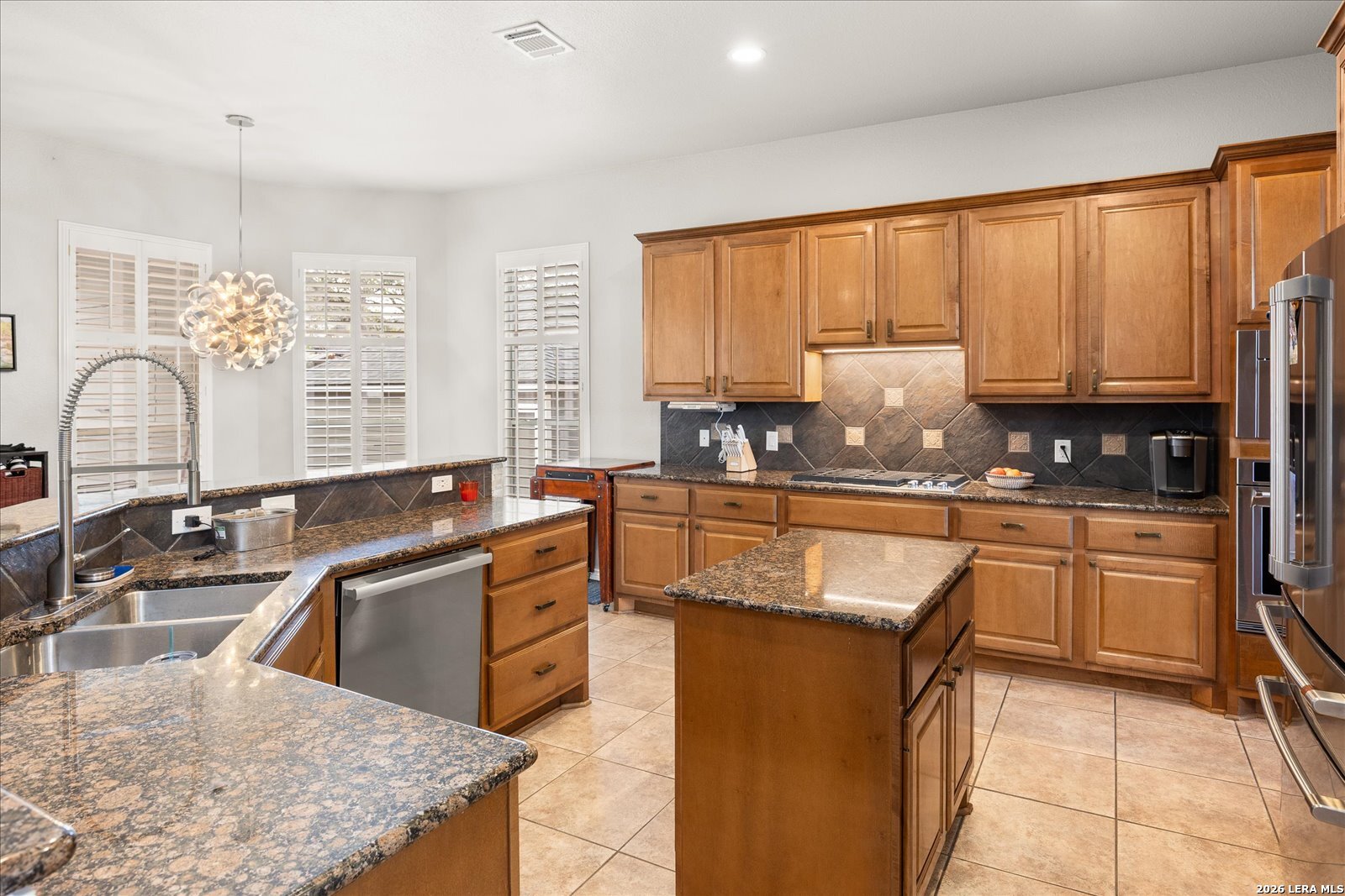 8718 Timberland Trail Fair Oaks Ranch, TX 78015 - Photo 20 of 50 a kitchen with stainless steel appliances granite countertop a stove sink and cabinets
