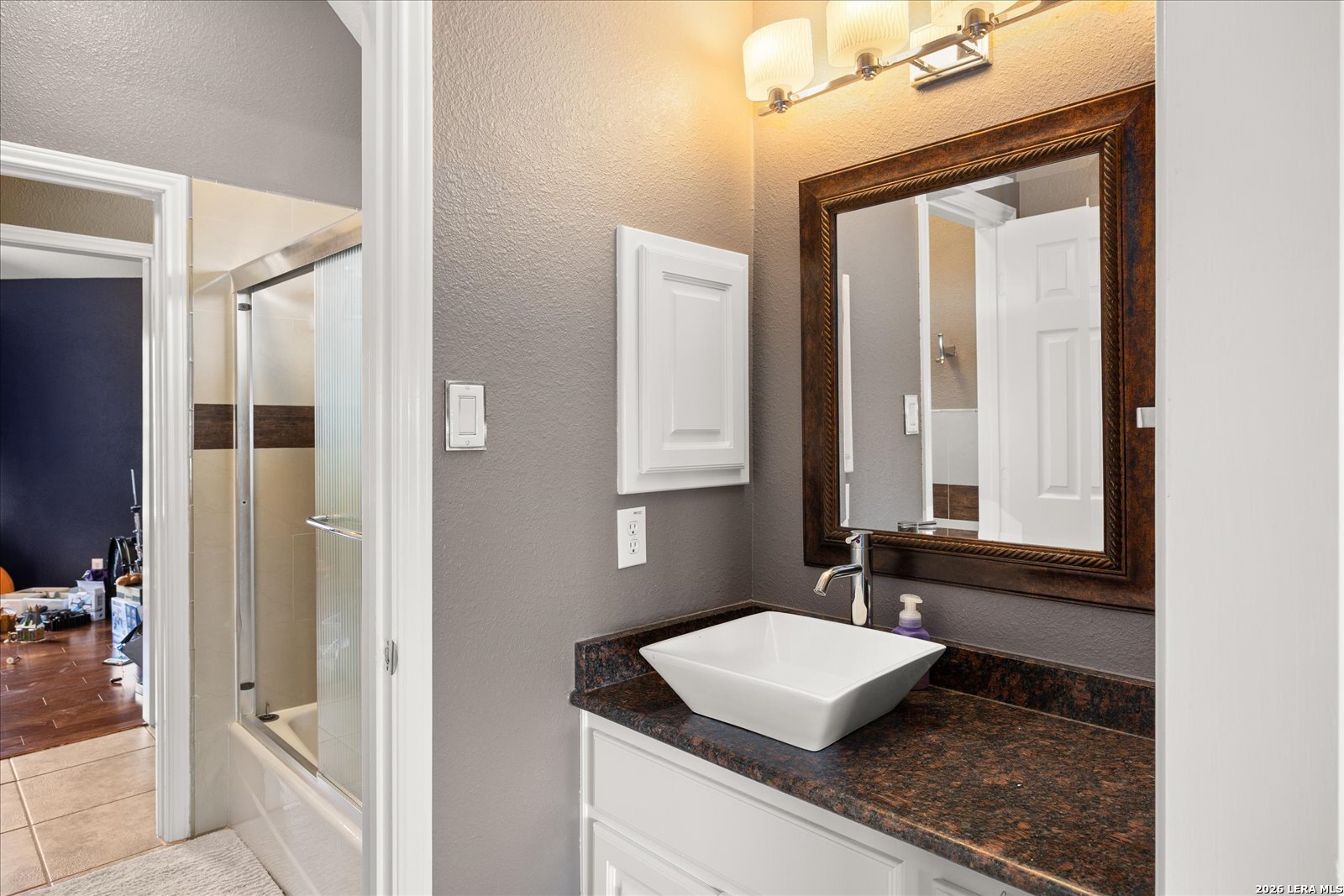 8718 Timberland Trail Fair Oaks Ranch, TX 78015 - Photo 37 of 50 a bathroom with a granite countertop sink and a mirror