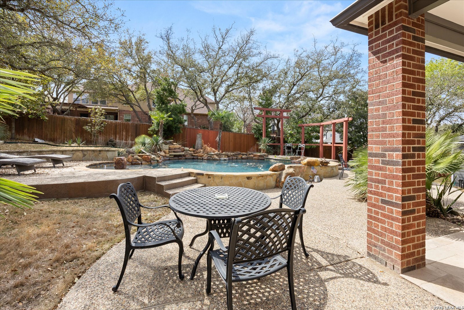 8718 Timberland Trail Fair Oaks Ranch, TX 78015 - Photo 39 of 50 a view of a patio with a dining table and chairs with wooden floor and fence