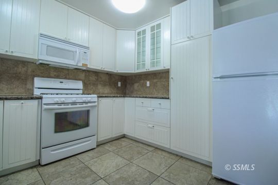1043 Peg Street Ridgecrest, CA 93555 - Photo 17 of 45 a kitchen with granite countertop white cabinets and white appliances