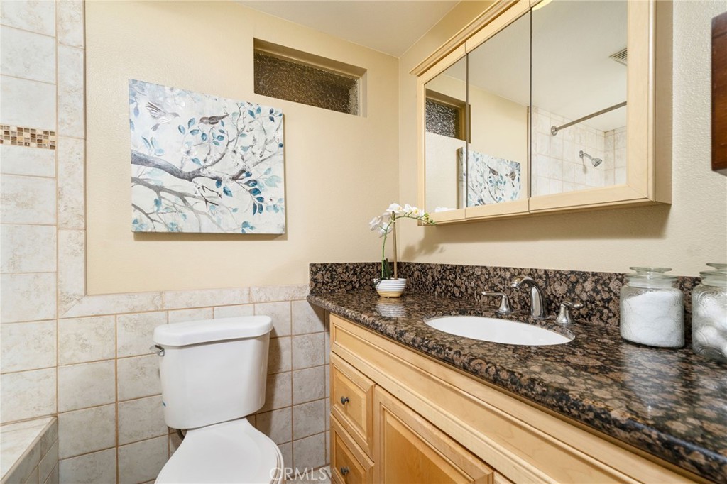 760 West Aster Street Upland, CA 91786 - Photo 15 of 40 a bathroom with a granite countertop toilet sink and mirror