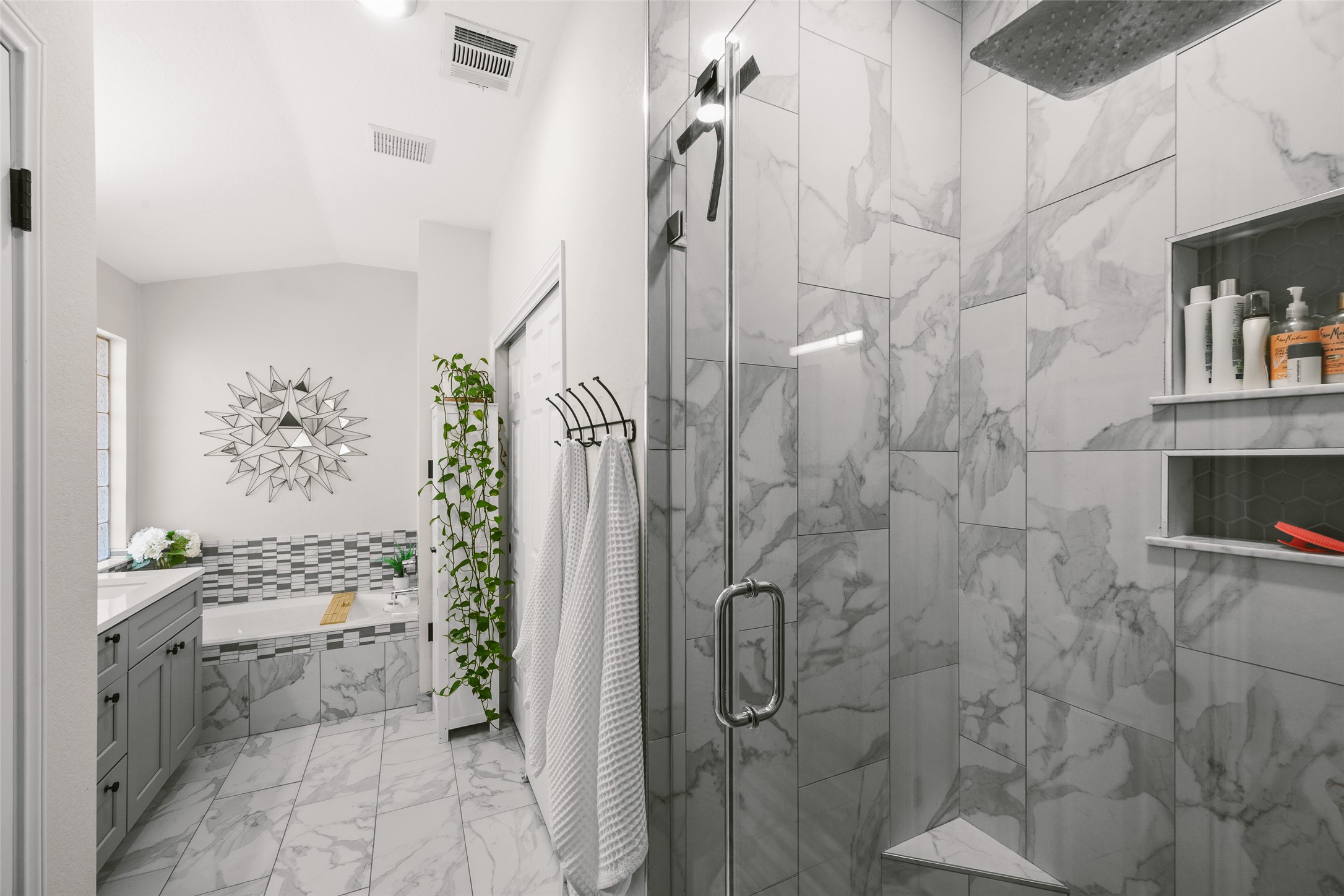 2202 Old Mill Road Cedar Park, TX 78613 - Photo 18 of 23 Marble-look tile envelops this modern bath, boasting a sleek shower and a luxurious soaking tub.