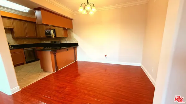 a view of kitchen with stainless steel appliances granite countertop cabinets and wooden floor